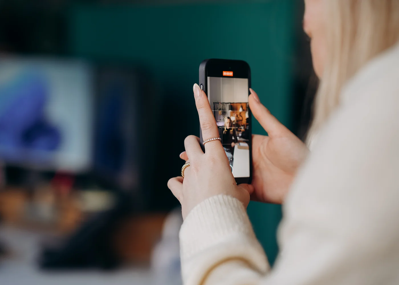 Über die Schulter fotografiert: ein Social-Media-Beitrag wird mit dem Smartphone aufgenommen